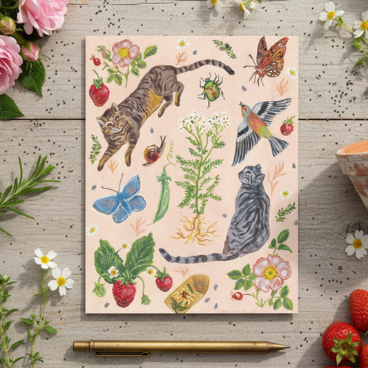 Greeting Card with cat and nature illustrations on a wooden surface with flowers and strawberries.
