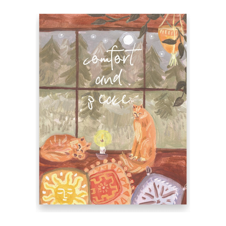 Postcards of two cats on a windowsill with colorful cushions and a nighttime forest outside, with the words, comfort and peace. Ingrid Press, made in the USA.