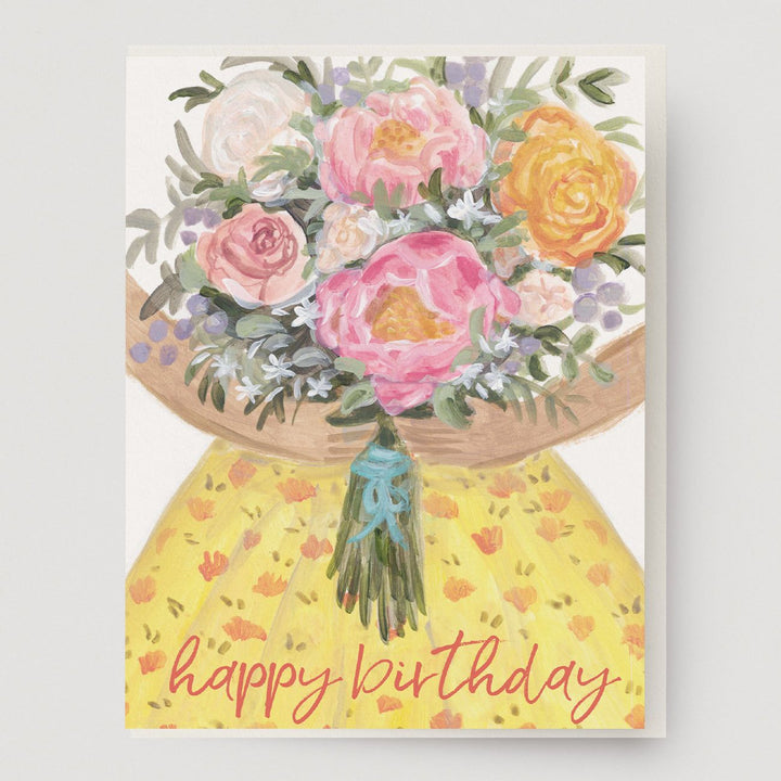 A birthday of hands holding a big bouquet of flowers and a patterned yellow dress with the words, "happy birthday" at the bottom. Hand illustrated by Mendocino Coast artist Katherine Lewis. Made by Ingrid Press card and gift company, ethically printed in the USA.