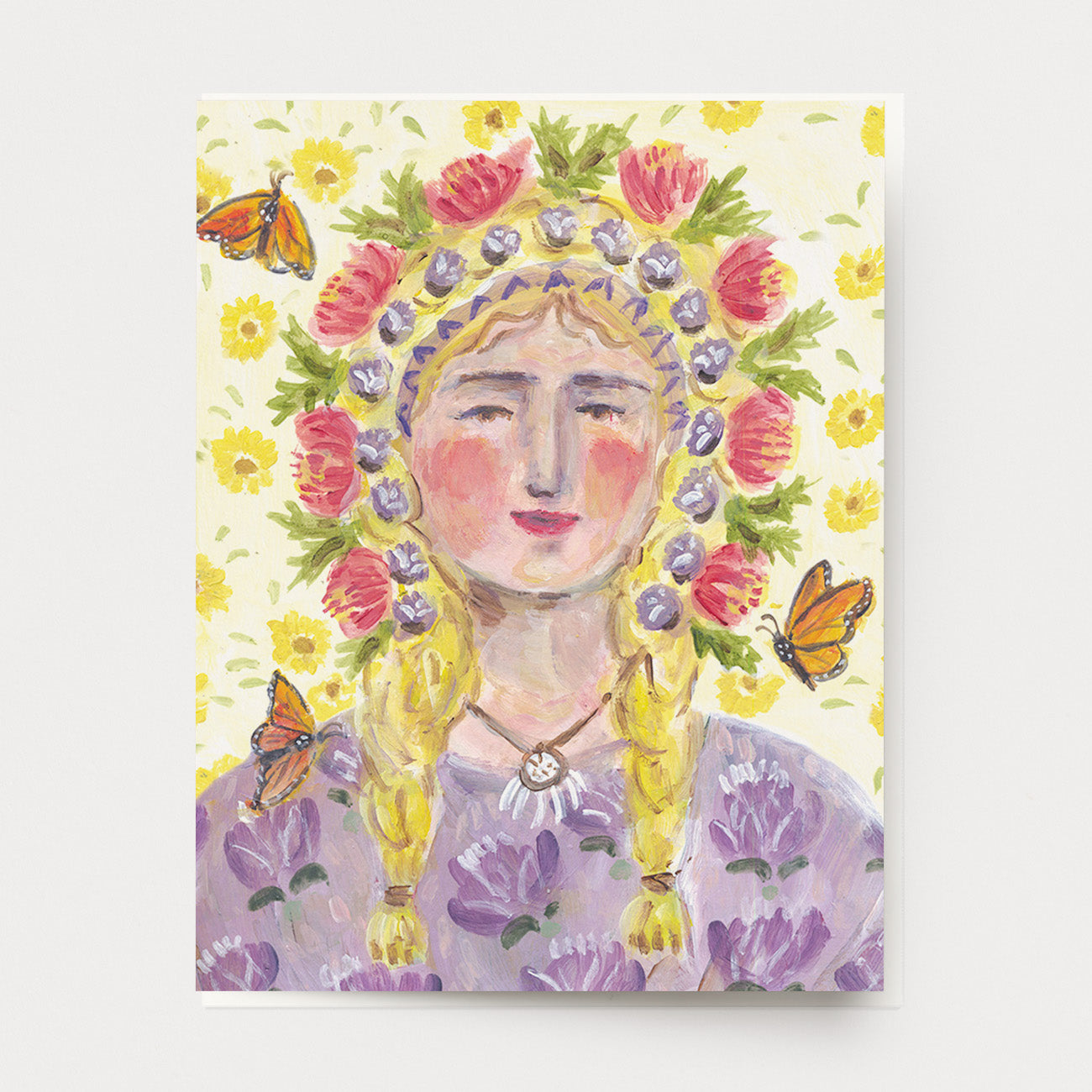 A greeting card of a peaceful blond woman with a colorful floral crown, a background of yellow flowers, a purple floral dress and monarch butterflies flying around.  Hand illustrated and made by Ingrid Press card and gift company, ethically printed in the USA. 
