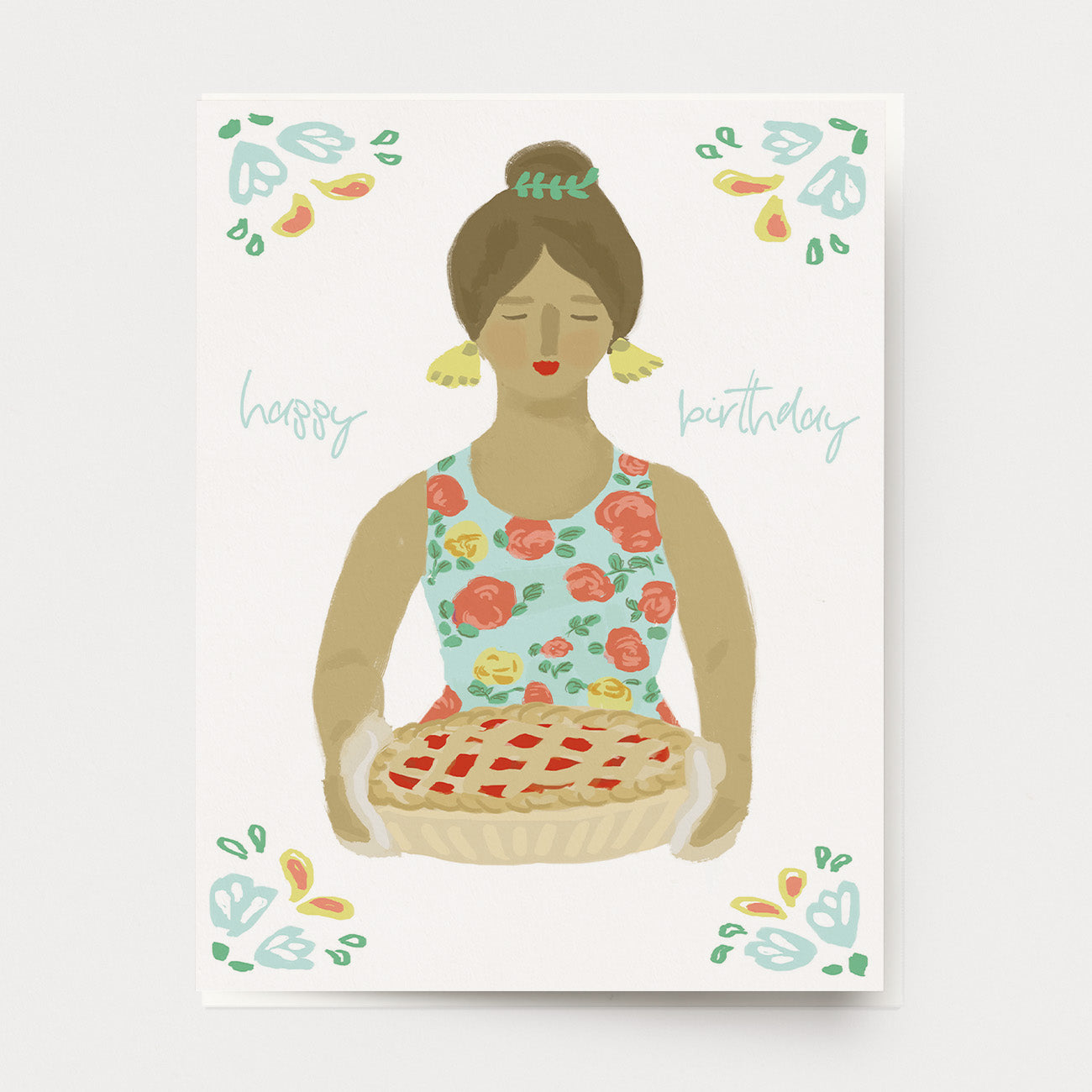 A birthday greeting card of a woman in a floral dress holding a fruit pie, with the words "happy birthday." Ingrid Press, made in the USA