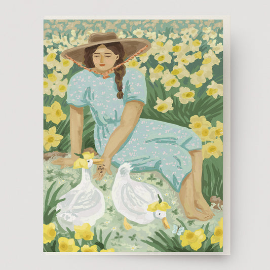 Greeting card of a woman and two ducks with flower hats in a field of daffodils. Ingrid Press, made in the USA.